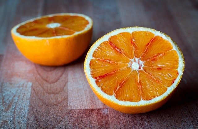 Rabbit next to orange slices on a clean surface